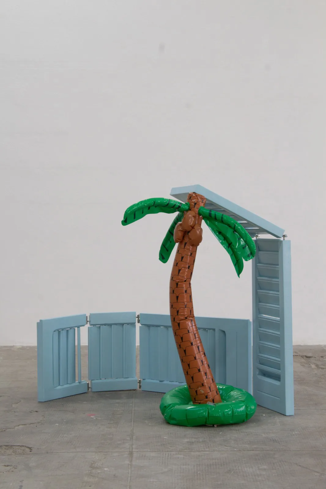 Angela Pillitteri, Cartolina dalle Bahamas, 2026. Wooden shutters, hinges, enamel, inflatable palm · 110 × 130 × 140 cm